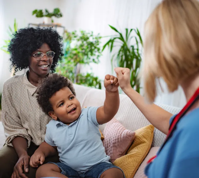 Home visit by family doctor providing medical care and advice in a family home setting.