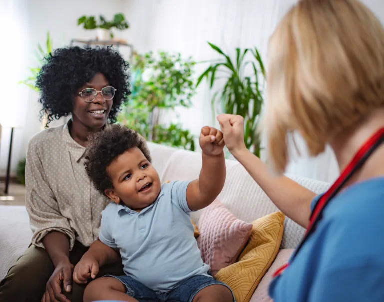 Home visit by family doctor providing medical care and advice in a family home setting.